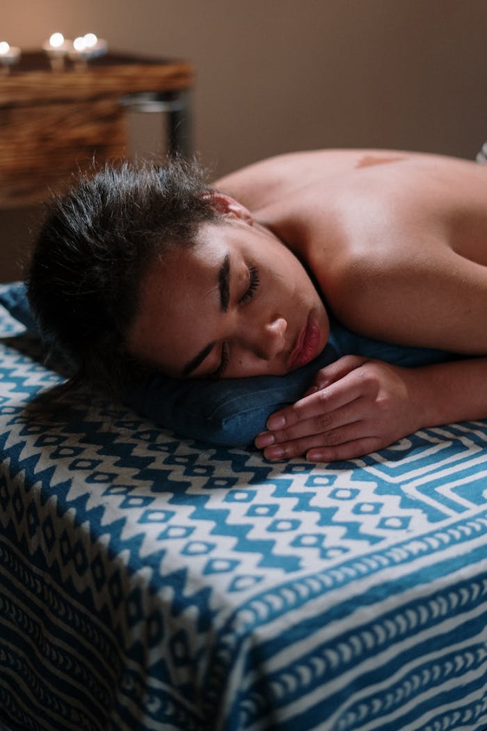 Woman enjoying a rejuvenating spa experience on a massage table for ultimate relaxation and wellbeing.